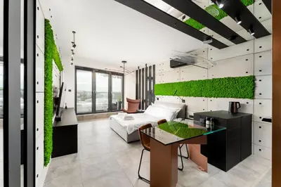a living room with a green wall at Wiślane Tarasy - UNIQUE Apartments 4YOU - 9 piętro z pięknym widokiem na centrum Krakowa in Kraków