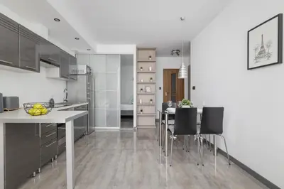 a kitchen with a table and chairs in a room at Apartament w Spokojnej Okolicy z Parkingiem by Noclegi Renters in Kraków