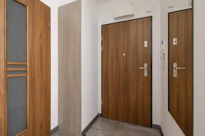 a row of wooden doors in a room at Apartament w Spokojnej Okolicy z Parkingiem by Noclegi Renters in Kraków