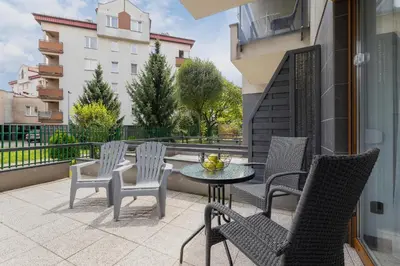 a patio with chairs and a table on a balcony at Apartament w Spokojnej Okolicy z Parkingiem by Noclegi Renters in Kraków