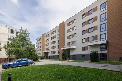 a blue car parked in front of a building at Apartament w Spokojnej Okolicy z Parkingiem by Noclegi Renters in Kraków