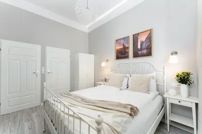 a white bedroom with a white bed and a desk at LORETO 1 by Cozyplace in Kraków