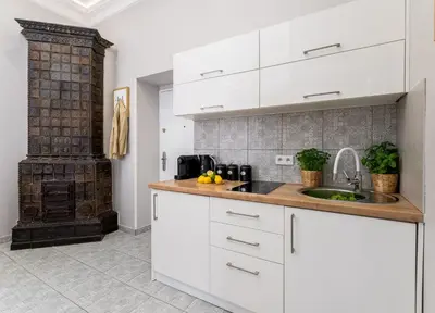 a kitchen with white cabinets and a sink at LORETO 1 by Cozyplace in Kraków