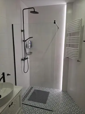 a white bathroom with a shower and a sink at Komfortowy apartament in Bochnia