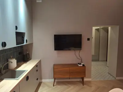 a kitchen with a flat screen tv on the wall at Komfortowy apartament in Bochnia