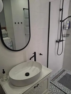 a white bathroom with a sink and a mirror at Komfortowy apartament in Bochnia