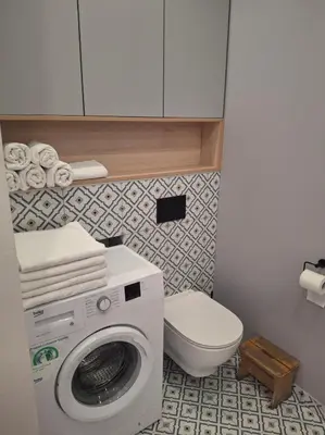 a bathroom with a washing machine and a toilet at Komfortowy apartament in Bochnia