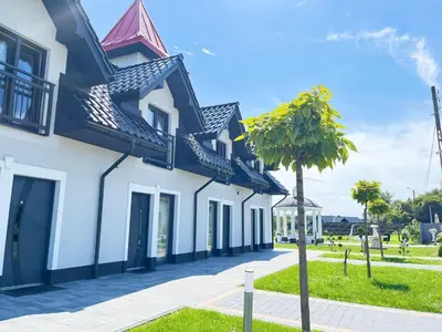 a white building with a tree in front of it at Apartamenty Artur in Oświęcim