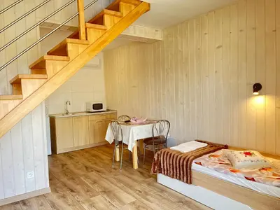 a room with a bed and a table and a staircase at Apartamenty Artur in Oświęcim