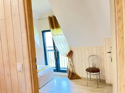 a room with a bed and a chair and a window at Apartamenty Artur in Oświęcim