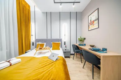 a hotel room with a bed and a desk and a desk at Platinia Premium Apartments in Kraków