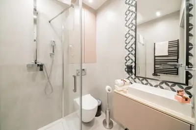 a bathroom with a shower and a toilet and a sink at Platinia Premium Apartments in Kraków