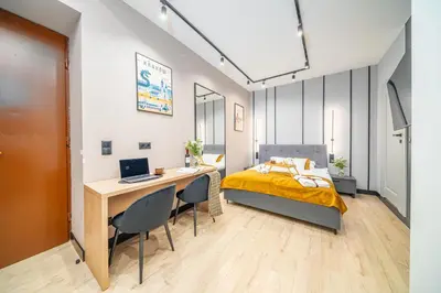 a bedroom with a bed and a desk with a laptop at Platinia Premium Apartments in Kraków