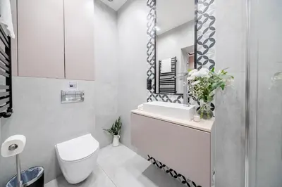 a white bathroom with a toilet and a sink at Platinia Premium Apartments in Kraków