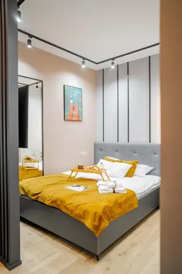 a bedroom with a large bed with yellow sheets at Platinia Premium Apartments in Kraków