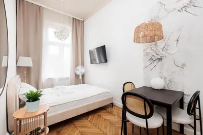a bedroom with a bed and a table and chairs at Comfort Central Studio - by Upstairs in Kraków