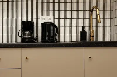 a kitchen counter with a sink and appliances on it at Comfort Central Studio - by Upstairs in Kraków