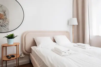 a bedroom with a bed with white sheets and a mirror at Comfort Central Studio - by Upstairs in Kraków