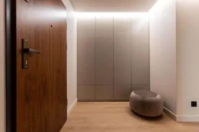 a room with a wooden door and a stool at Boutique Wawel Side in Kraków