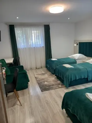 a hotel room with two beds and a chair at Komfortowe pokoje przy Szymonowica w Krakowie in Kraków