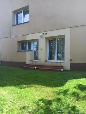 a house with a green lawn in front of it at Komfortowe pokoje przy Szymonowica w Krakowie in Kraków