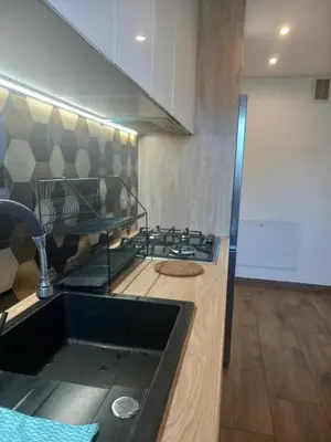 a kitchen with a sink and a stove at Komfortowe pokoje przy Szymonowica w Krakowie in Kraków
