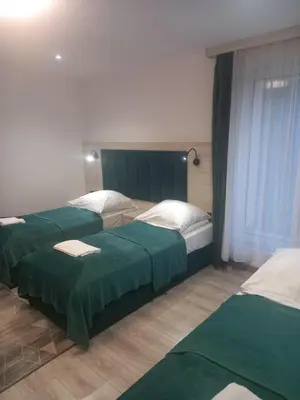 a hotel room with two beds with green sheets at Komfortowe pokoje przy Szymonowica w Krakowie in Kraków
