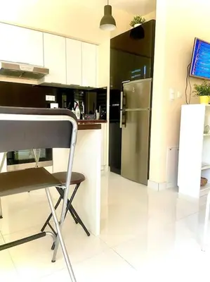 a kitchen with a refrigerator and a table and a chair at Apartament Grzegórzecka centrum in Kraków