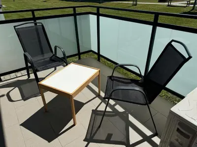 two chairs and a table on a balcony at Luksusowy Apartament in Jaworzno