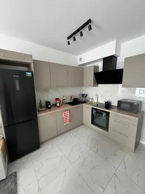 a large kitchen with a black refrigerator and appliances at Luksusowy Apartament in Jaworzno