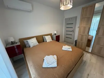 a bedroom with a large bed with towels on it at Luksusowy Apartament in Jaworzno