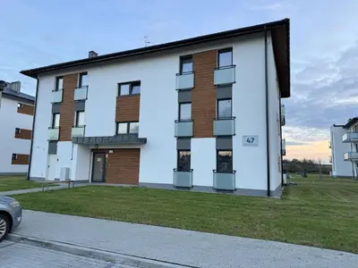 a large white building with a car parked in front of it at Luksusowy Apartament in Jaworzno