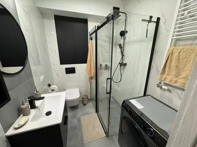 a bathroom with a shower and a sink and a toilet at Luksusowy Apartament in Jaworzno