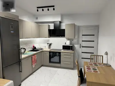 a kitchen with white appliances and a wooden table at Luksusowy Apartament in Jaworzno