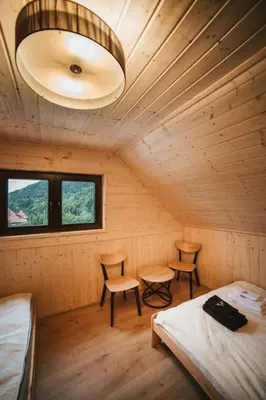 a room with two beds and two chairs in a cabin at Chata Zawrot in Wytrzyszczka