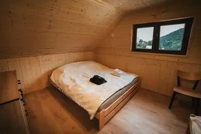 a room with a bed in a cabin with a window at Chata Zawrot in Wytrzyszczka