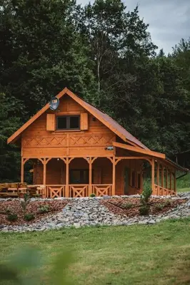 a large wooden cabin in the middle of a field at Chata Zawrot in Wytrzyszczka