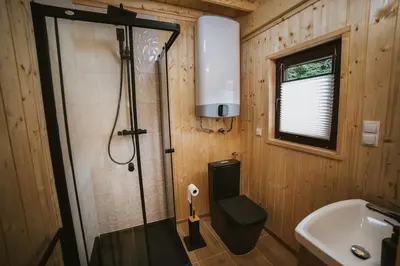 a bathroom with a shower and a toilet and a sink at Chata Zawrot in Wytrzyszczka