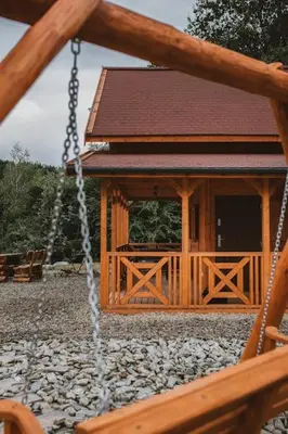 a wooden gazebo with a porch and a swing at Chata Zawrot in Wytrzyszczka