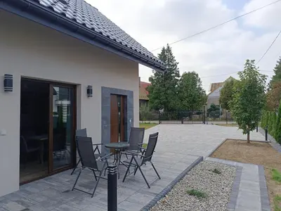 a patio with a table and chairs in a yard at Noclegi u Edyty in Zator