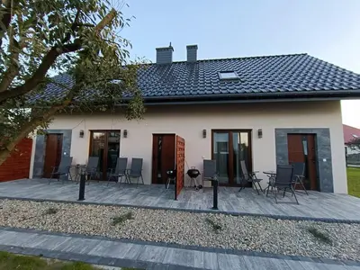 a house with a deck and chairs in front of it at Noclegi u Edyty in Zator