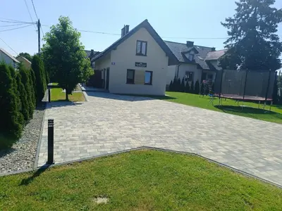 a driveway in front of a white house at Noclegi u Edyty in Zator