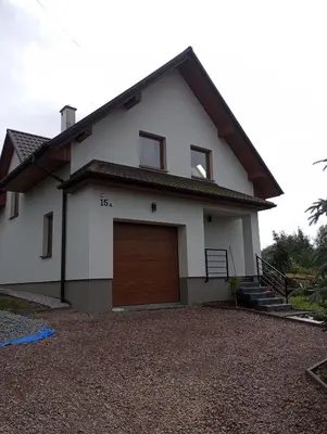 a white house with a brown garage at Cracow house under walnut tree in Kraków