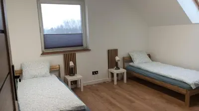 a small room with two beds and a window at Cracow house under walnut tree in Kraków