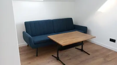 a blue couch and a wooden table in a room at Cracow house under walnut tree in Kraków