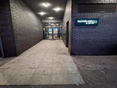 an empty hallway with a sign on a brick wall at Riverside Studio in Kraków