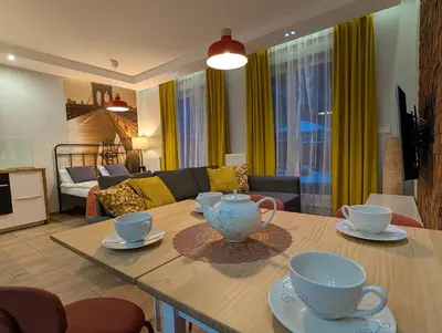 a living room with a table with two tea cups on it at Riverside Studio in Kraków