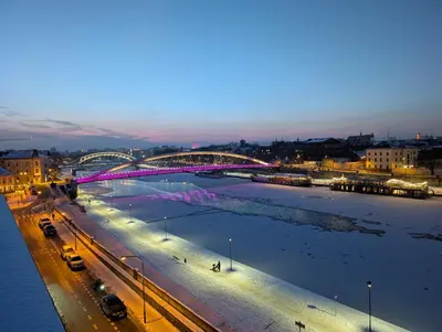 a lit up bridge over a river at night at Riverside Studio in Kraków