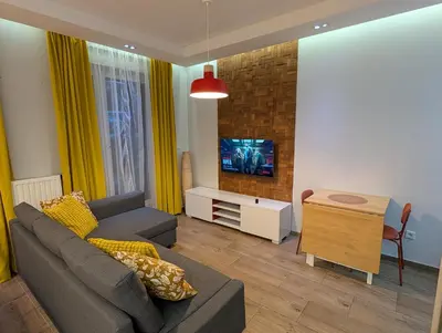 a living room with a couch and a tv at Riverside Studio in Kraków