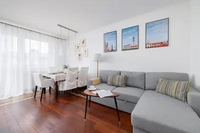 a living room with a couch and a table at Cozy Apartment with Parking in Kraków by Noclegi Renters in Kraków